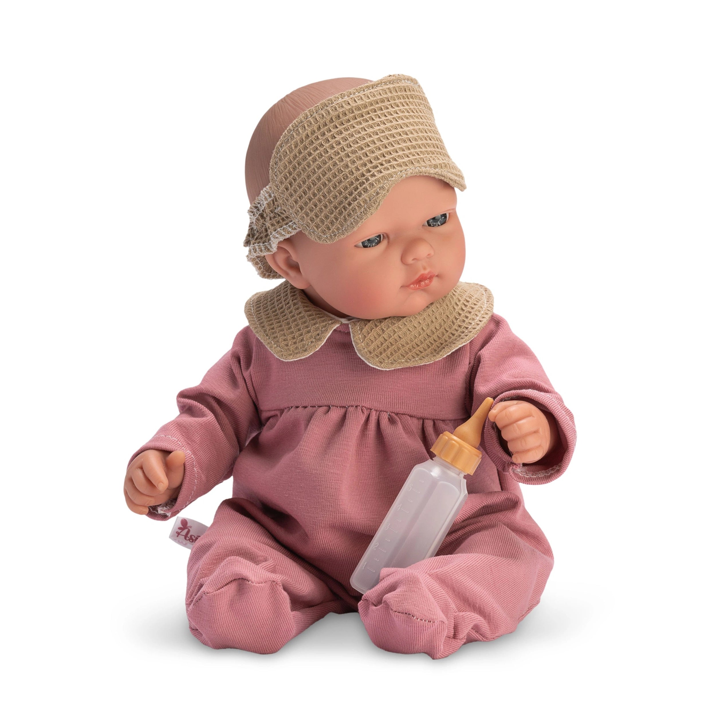 Bald doll in pink pajamas with mask, holding a bottle, seated with articulated limbs.