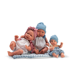 Three ASI Dolls sitting on a soft mat. Two wear pink headbands, one wears a blue hat. Each dressed in pastel outfits.