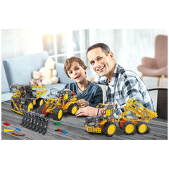 Father and son building colorful construction vehicles from the Alexander - Pro Muck Truck Constructor Set on a wooden table.
