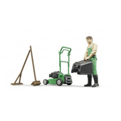 Gardener toy with green overalls, lawnmower, rake, and broom.