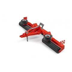 Red Bruder Cambridge Roller toy with black rollers and silver details, designed for imaginative agricultural play.