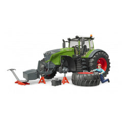 Bruder Fendt 1050 Vario toy tractor with mechanic, tools, and large tire on jack stands.