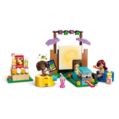 LEGO Friends Friendship Movie Night set featuring two minidolls, a mini projector with light, popcorn cart, and colorful seating for a fun outdoor movie experience.