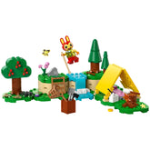 Colorful LEGO® Animal Crossing™ construction set featuring Bunnie the rabbit, a yellow tent, trees, a waterfall, and camping accessories.