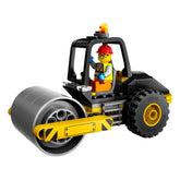 LEGO City Construction Steamroller with a smiling construction worker minifigure in a red hard hat, seated in a vibrant yellow and black vehicle, featuring chunky tires and a shiny rolling drum.