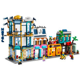 LEGO® Creator 3in1 Main Street set featuring a vibrant cityscape with a three-floor hotel, lively music and record stores, and a café, alongside mini-figures interacting on the street.