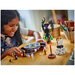 Young girl joyfully assembling LEGO® Disney construction set featuring Maleficent and Cruella De Vil's dresses, with colorful figurines and accessories on a wooden table.