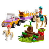 LEGO® Friends Horse and Pony Trailer set featuring a colorful car towing a horse trailer, two mini figurines, a horse, and a pony on a grassy landscape.