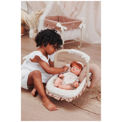 ASI Dolls Maxi Cosi for Dolls with a child playing on the floor, featuring a doll in a stroller with a cozy surrounding.