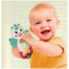 Baby Clementoni Little Unicorn Rattle is held by a smiling child in a yellow top, showcasing its colorful, friendly design.