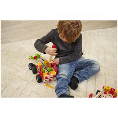 Eichhorn Constructor Truck set with colorful blocks is being played with by a young child on a soft carpet.