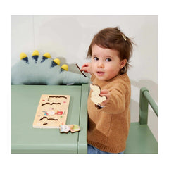 Eichhorn Puzzle Friends featuring a child with a wooden puzzle piece and a dinosaur toy in a bright play area.