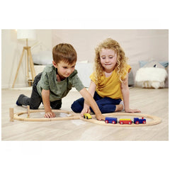 Eichhorn Train Track Playset features two children playing with colorful wooden trains on a minimalistic room floor.