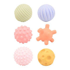 Bio Plastic Motor and Sensory Balls in pink, yellow, and blue, textured foam surface arranged in a grid pattern.
