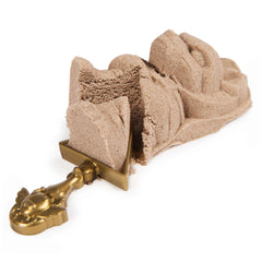 Kinetic Sand Mummy Tomb in light brown with a matte finish, featuring a central hole, placed on a flat surface.