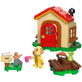 LEGO Animal Crossing set features a yellow dog figure with brown spots holding a pink cup beside a colorful house.