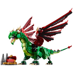 A colorful Lego Medieval Dragon with green and red wings, displaying posable limbs and a fierce expression, stands beside a treasure chest.