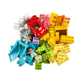 A vibrant collection of LEGO® DUPLO® bricks, featuring a red toy car, colorful building pieces, and two child figures, set against a white background.
