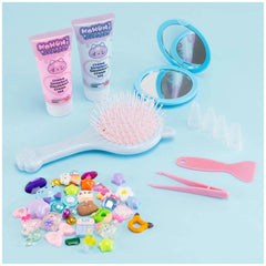 Momomi Decoden Kawaii Artist creamy mirror and brush with pink bristles, showcased against a solid light blue background.