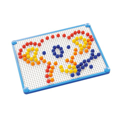 Quercetti FantaColor Tab Basic features a blue plastic grid with colorful pegs arranged to form a face pattern.