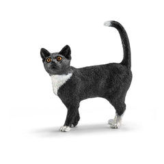 Black and white cat figurine standing upright with orange eyes and a curved tail, showcasing a smooth surface.