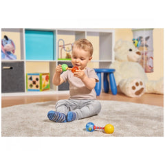 Simba - ABC First Rattle with child on carpet, colorful rattle, teddy bear, and toy shelf in a playful setting.