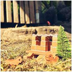 Teifoc chicken coop features a handcrafted wooden structure in a rural setting with an artificial green tree in front.