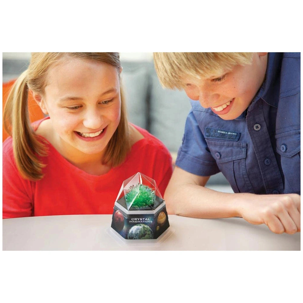 4M Crystal Growing Blue Edition toy playset showcased under a plastic dome with a glass base, featuring two children in color
