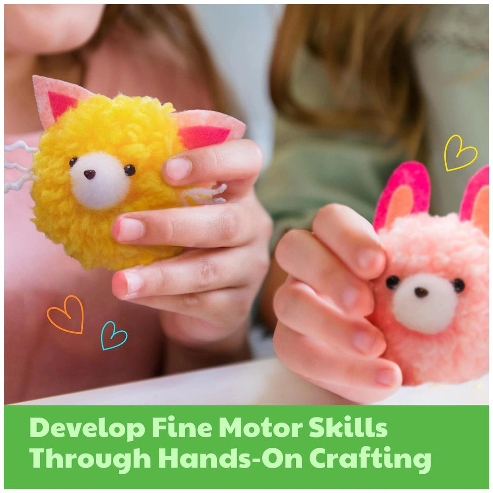 4M Make Your Own Pom Pom kit showcased with hands holding a small stuffed animal featuring a smiling face and pink details.