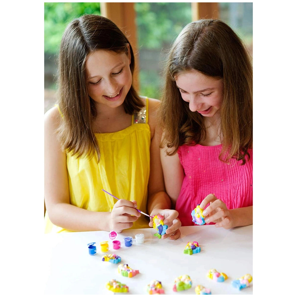 4M Mould & Paint Glitter Crafts displayed as two girls in yellow and pink dresses cut colorful material with purple-handled s