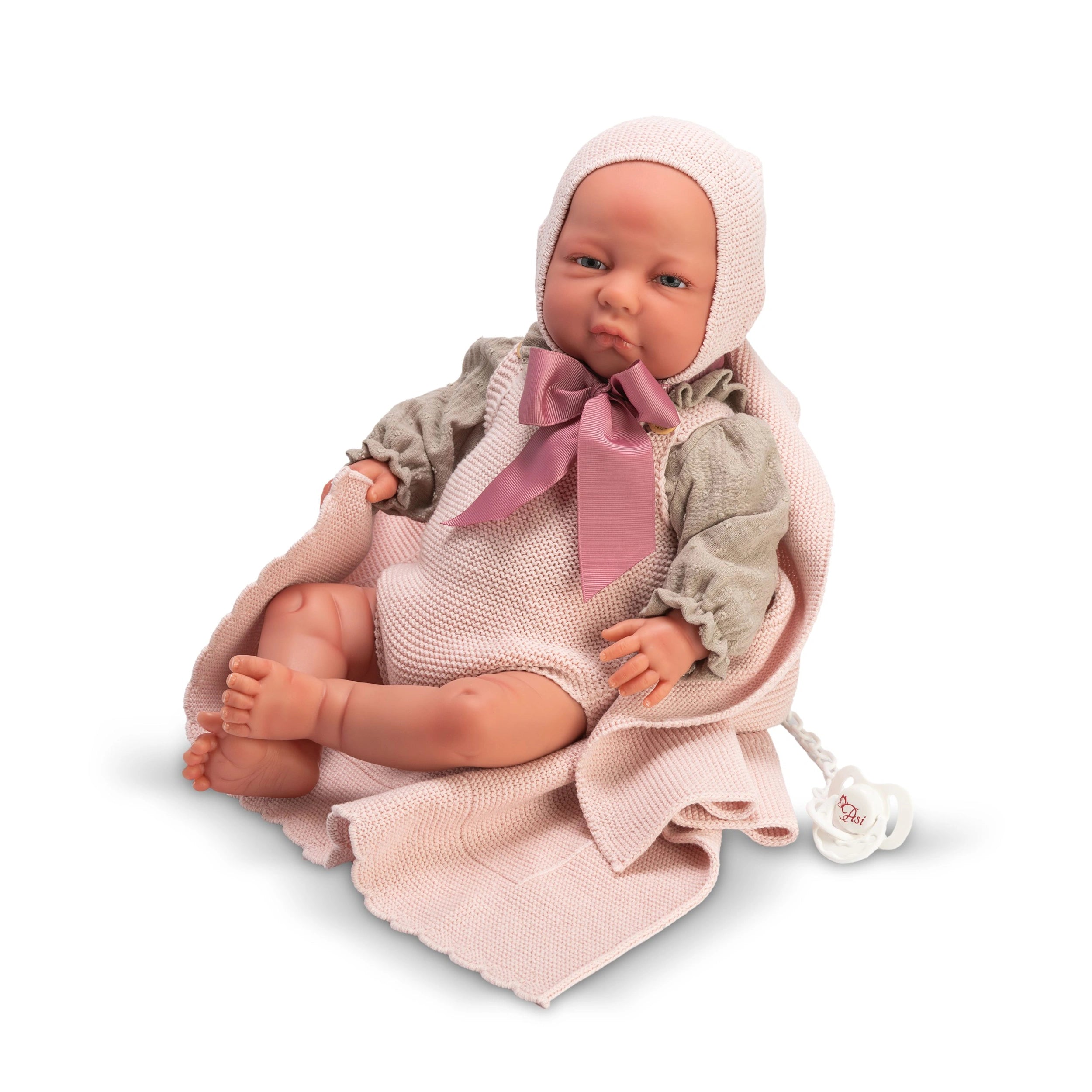 Lifelike ASI Dolls Katty Reborn Doll wearing a pink knit outfit with bow, sitting on a matching blanket.
