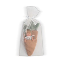 Blonde doll wrapped in a carrot-shaped pouch with green felt leaves, dressed in a patterned shirt, nestled in a sheer bag.