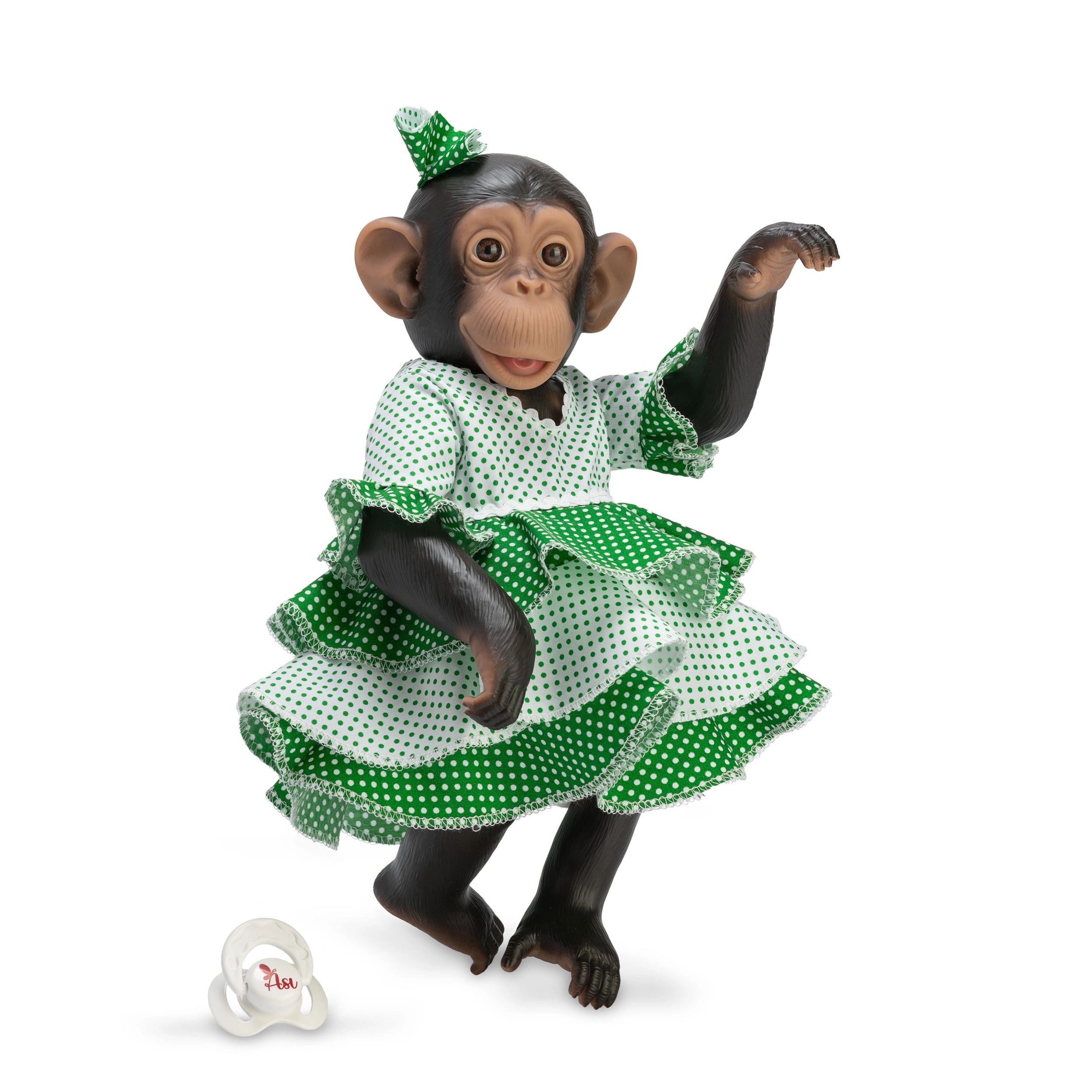 Chimpanzee doll in a green polka dot flamenco dress, posed with an upraised arm, accompanied by a pacifier.