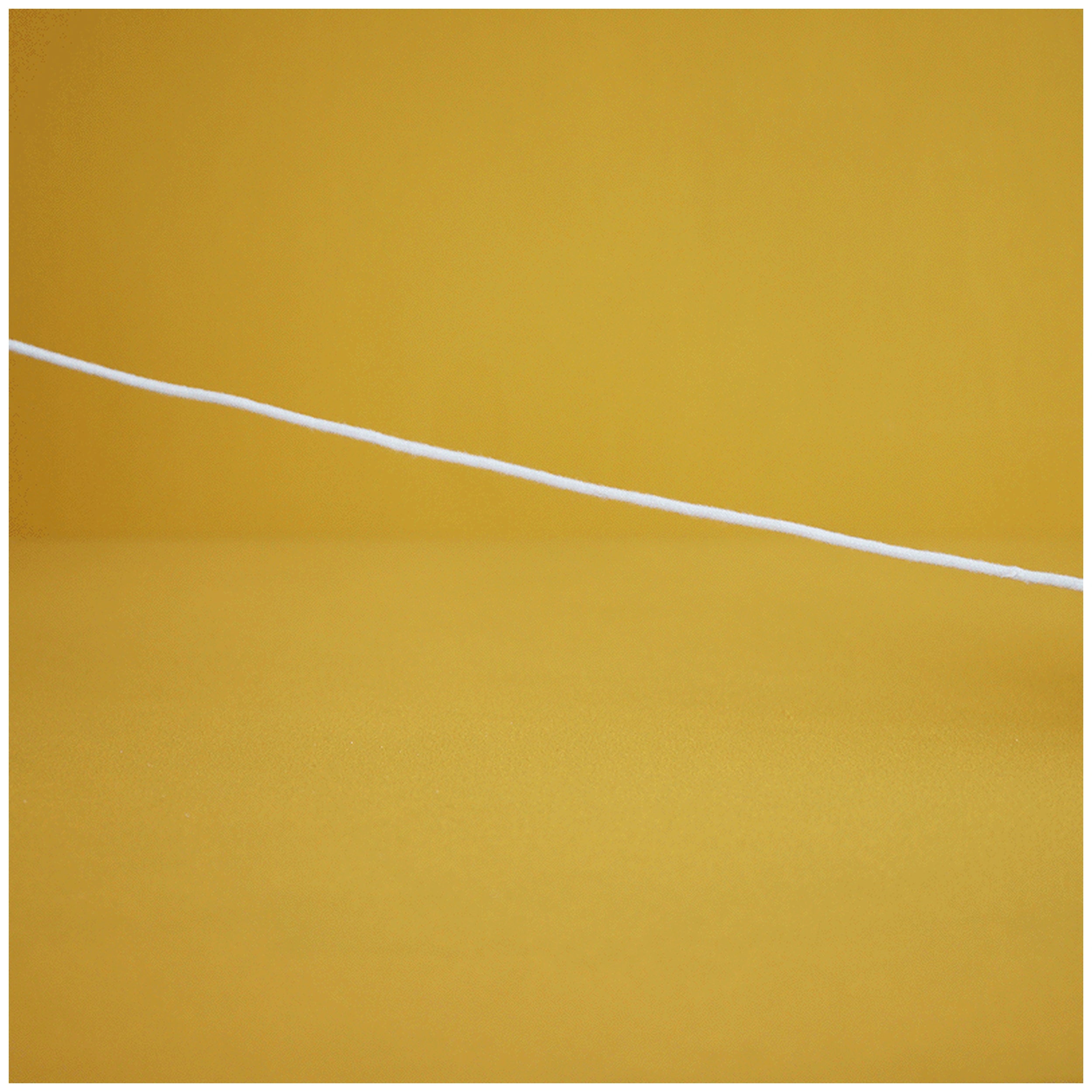 A white cotton cord stretches across a vibrant yellow background, suggesting playfulness and connection for children's toys.