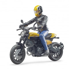 Toy figure on yellow Scrambler Ducati motorcycle with detailed rider, black helmet, and leather gear, on white background.