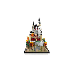 LEGO Architecture Neuschwanstein Castle model featuring intricate details, towering spires, and vibrant landscaping with orange flowers.
