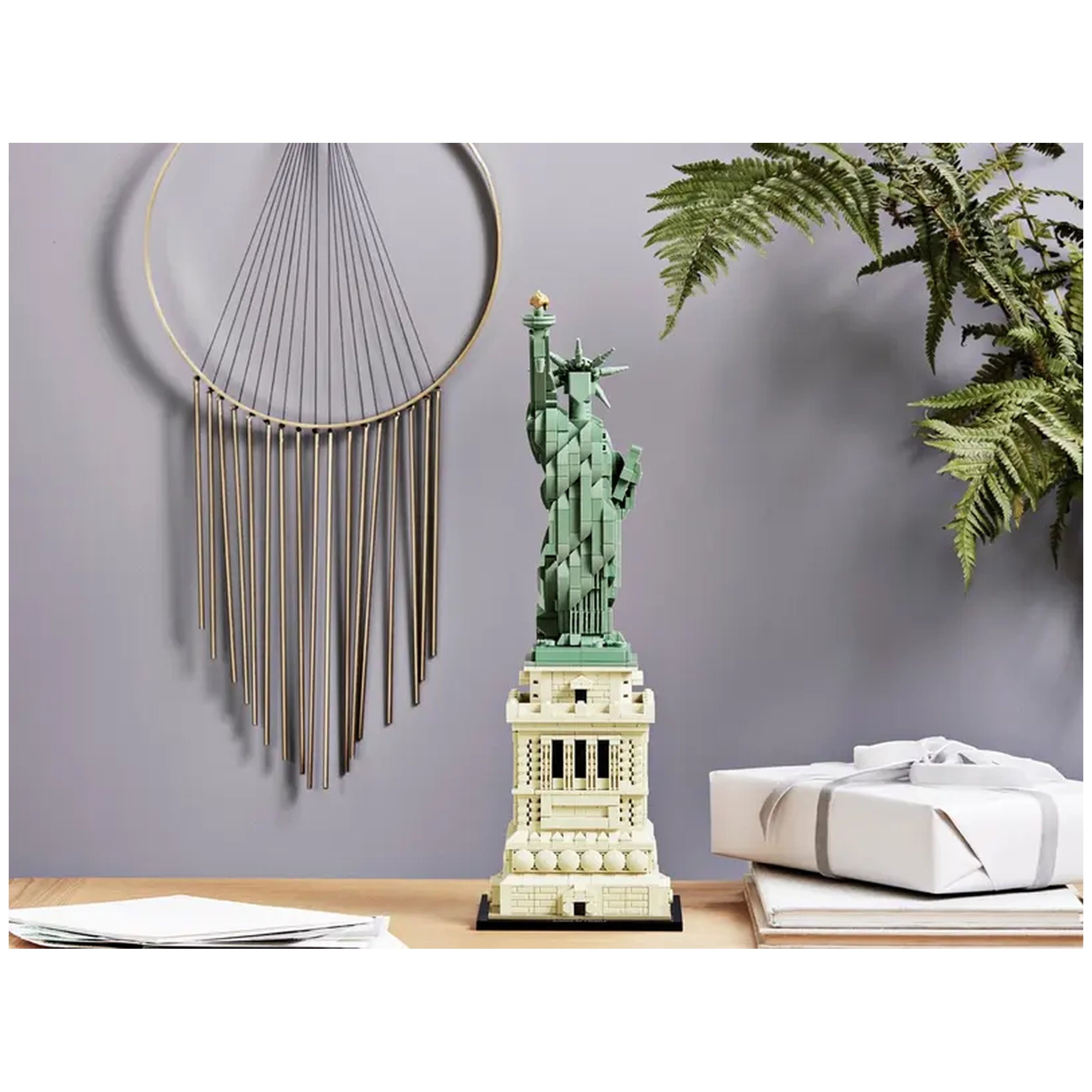 LEGO® Architecture Statue of Liberty model, standing over 17 inches tall, features intricate details and a golden torch, placed on a wooden table with decorative elements in a modern setting.