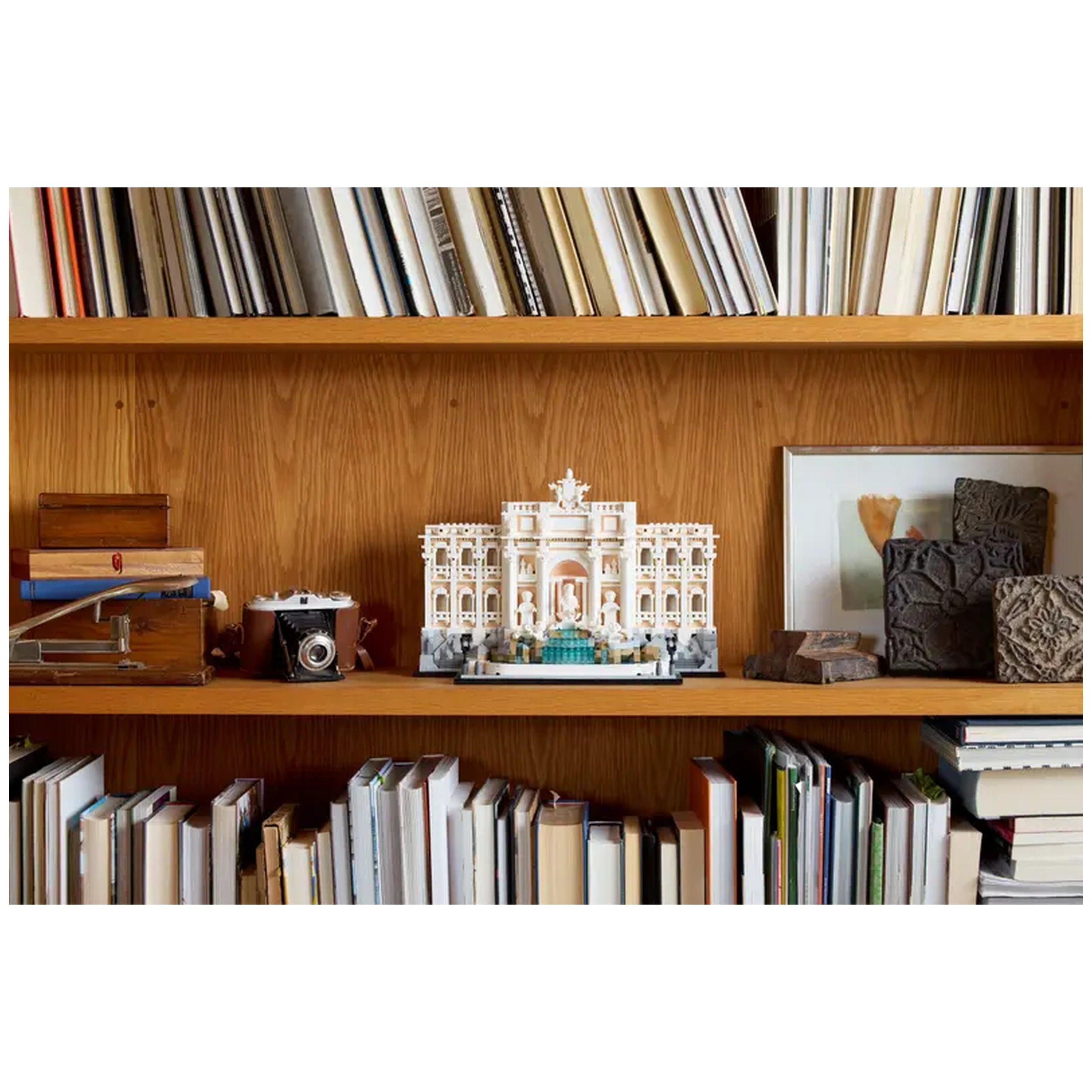 LEGO® Architecture Trevi Fountain set displayed on a wooden shelf, surrounded by books and decorative items, showcasing its intricate details.