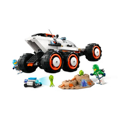 LEGO® City Space Explorer Rover with six oversized tires, two space crew minifigures, and alien figures exploring rocky terrain and crystal formations.