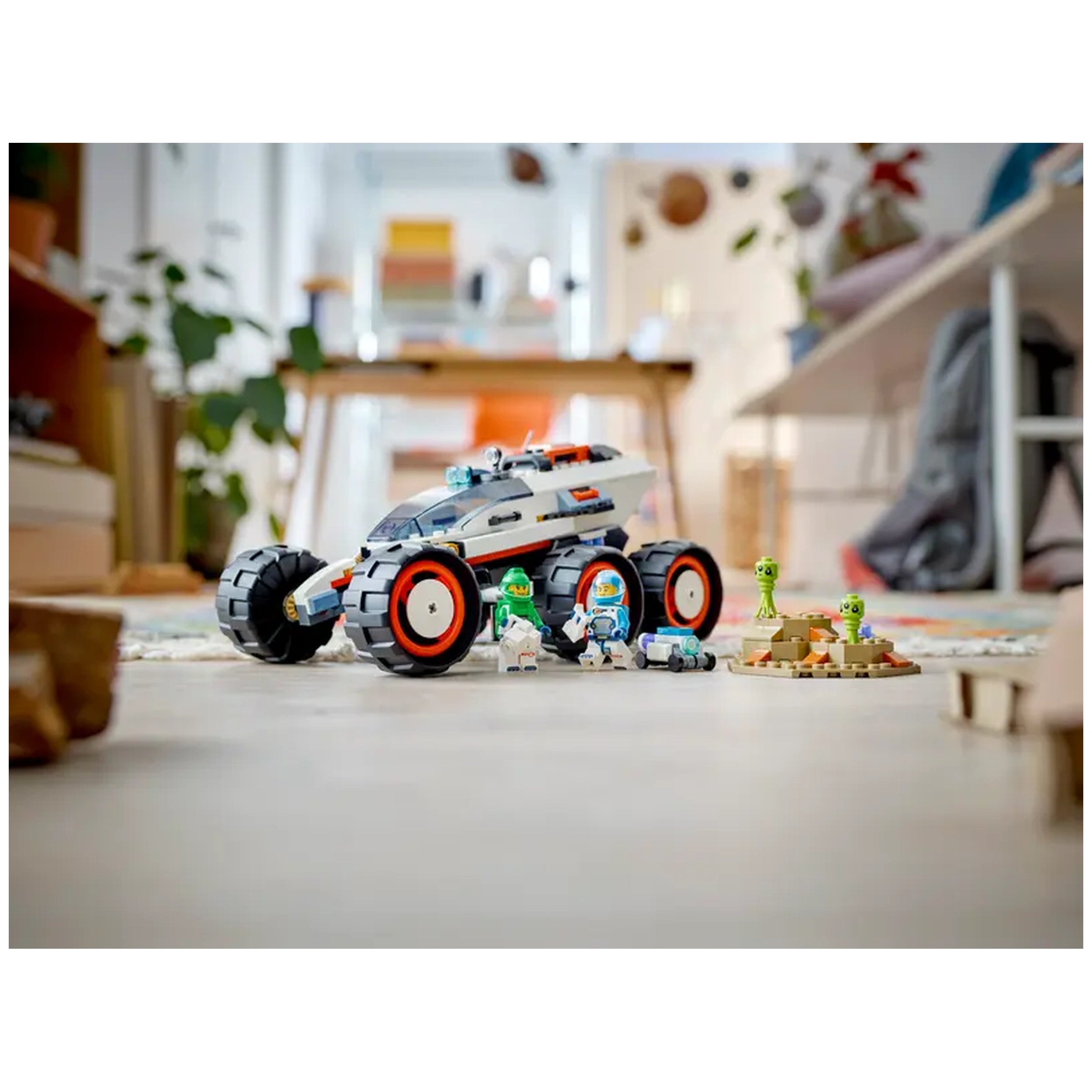 Lego City Space Explorer Rover with oversized tires, two space crew minifigures, a robot, and alien figures on a colorful play mat.
