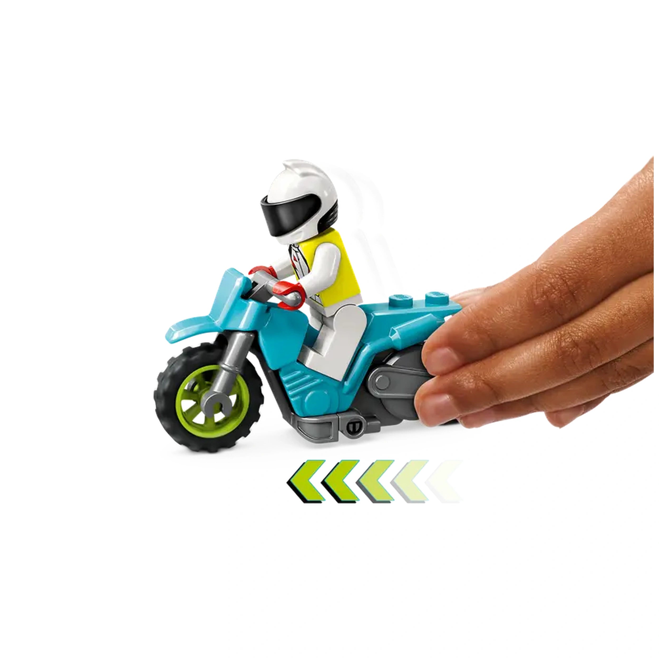 A hand pushes a bright blue stunt motorcycle with a minifigure in a white helmet and yellow shirt, ready for action.