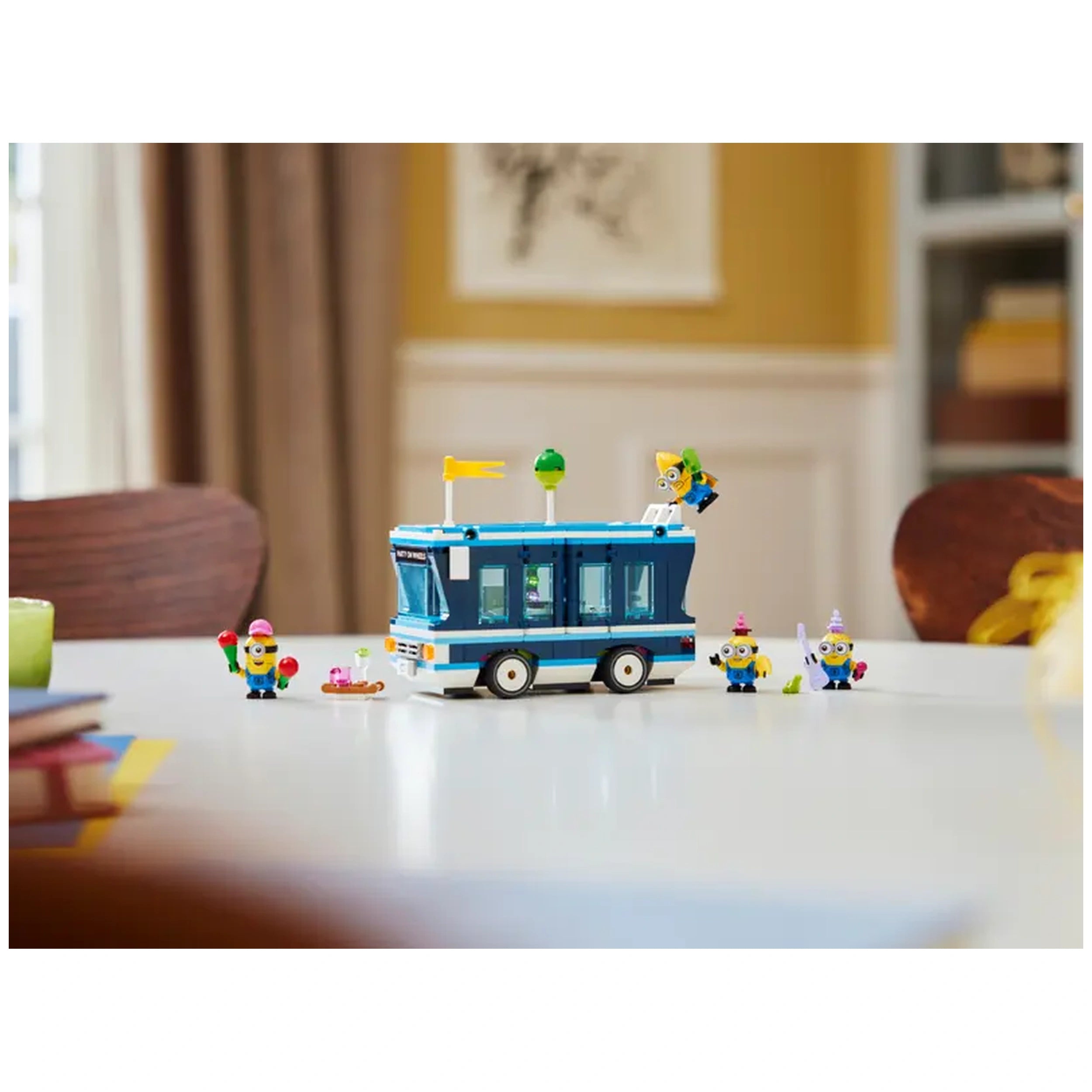 Colorful Lego Minions' Music Party Bus on a table, featuring playful Minion figures with accessories, set in a bright room.