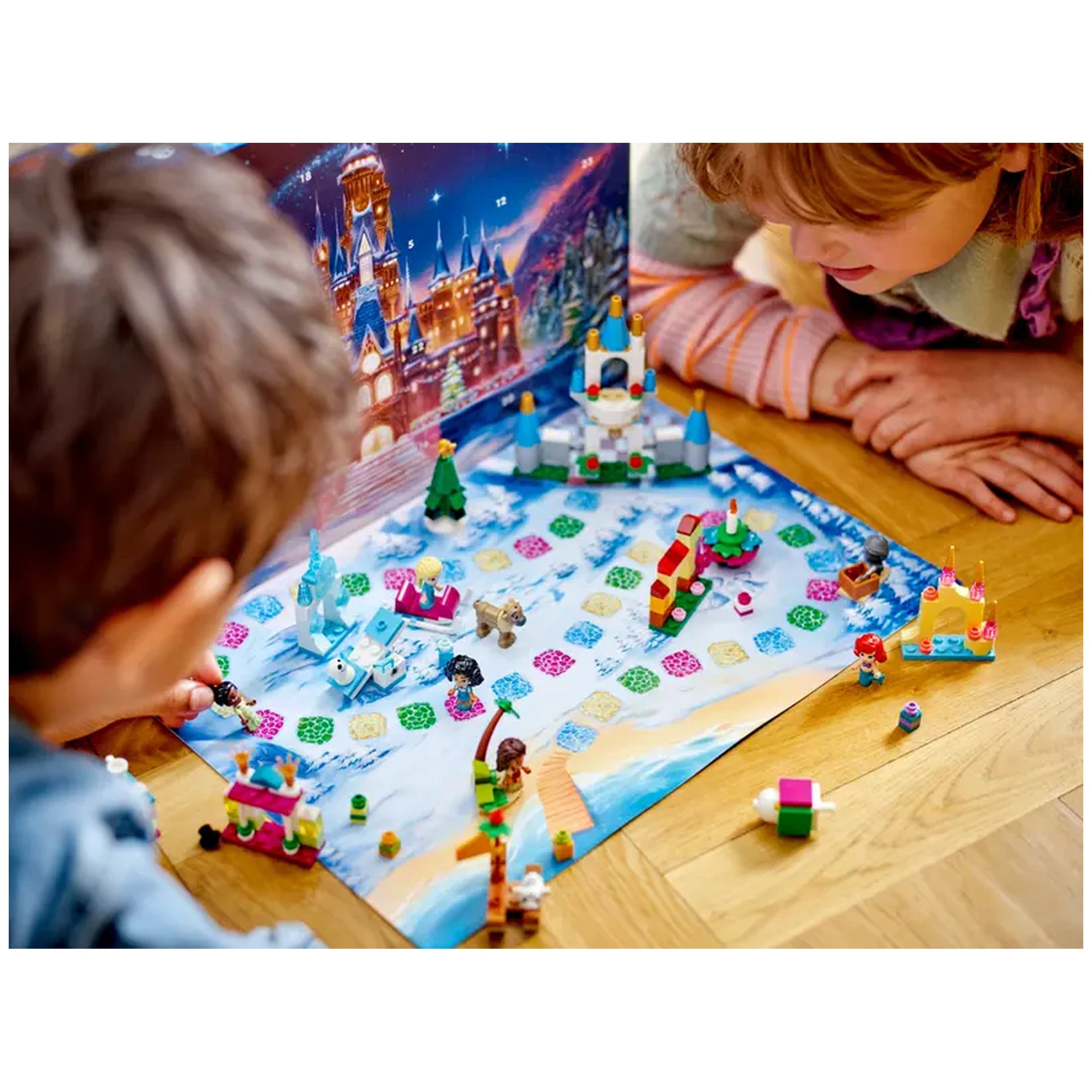 Children playing with the LEGO® | Disney Advent Calendar on a colorful snowy landscape, featuring micro-doll figures and mini builds.