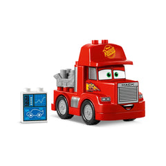 Red LEGO® DUPLO® Mack truck with smiling face and large green eyes, alongside a blue and white tuning station accessory.
