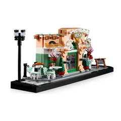 LEGO® Icons French Café construction set featuring a charming bistro facade with flowerpots, tables, streetlight, and a sidewalk.