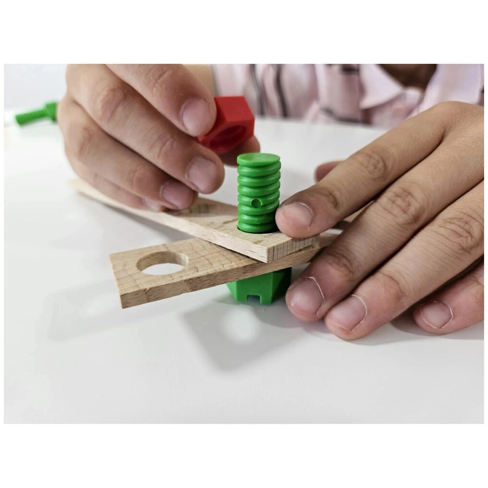 Child assembling wooden helicopter with green screw and red connector from Alexander Constructor Junior set.