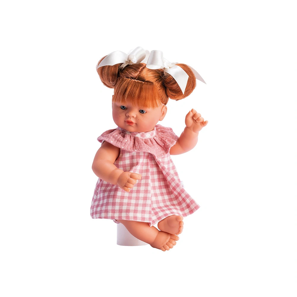 Red-haired doll in pink plaid dress with a chiffon collar and pigtails, on a white background.