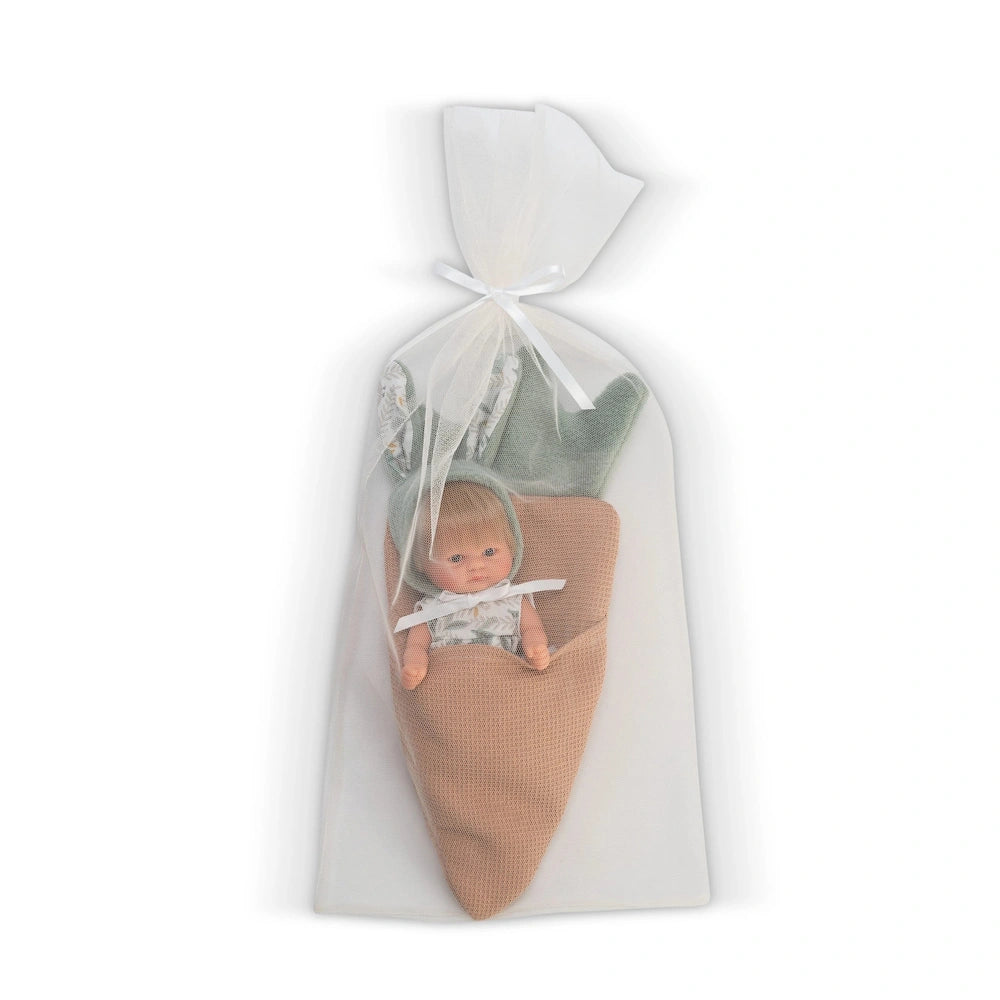 Blonde doll wrapped in a carrot-shaped pouch with green felt leaves, dressed in a patterned shirt, nestled in a sheer bag.