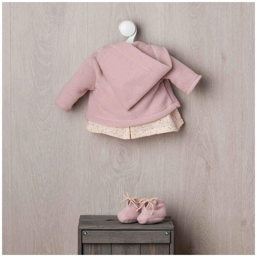 ASI Dolls - María Doll Outfit features a pink cardigan with hood and matching baby shoes on a wooden surface.
