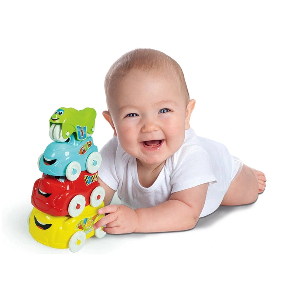 Baby enjoying colorful Fun Vehicles sorting and stacking toys, smiling while lying on a white surface.